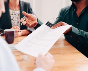 A man handing over papers asking for a signature.