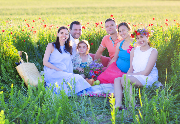 is polyamorous relationship marriage legal in canada - polyamorous famiy in a green field with one children and one pregnant woman