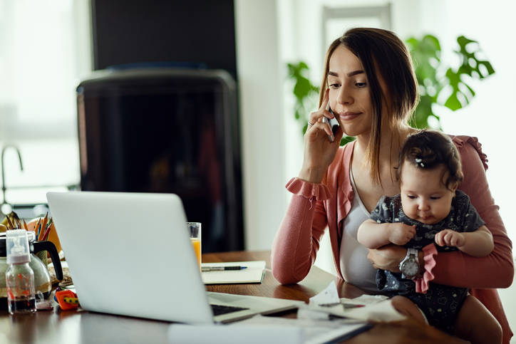 woman on phone with child on knee