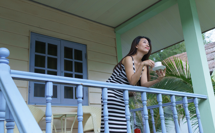 woman drinking coffee on porch